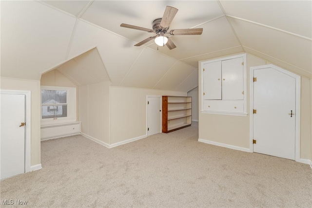 additional living space with light carpet, ceiling fan, baseboards, and vaulted ceiling