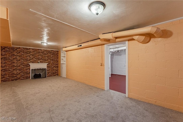 finished below grade area featuring carpet floors, concrete block wall, and a fireplace