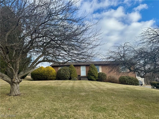 view of front facade featuring a front lawn and brick siding