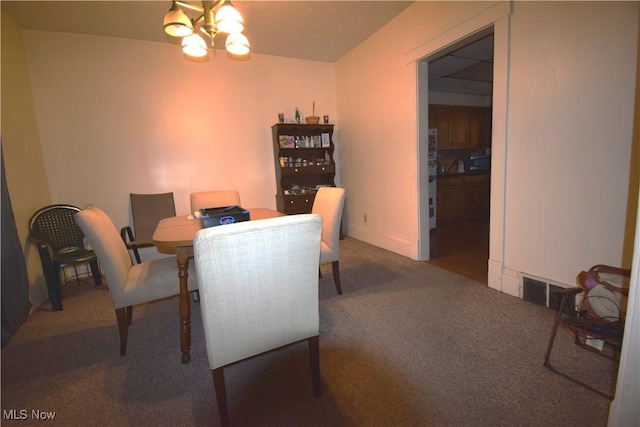 carpeted dining area featuring visible vents and a chandelier