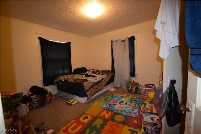 bedroom featuring carpet and a textured ceiling