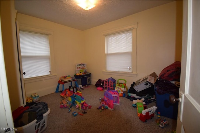 playroom featuring carpet floors and a textured ceiling