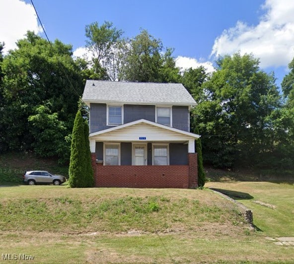 traditional home with brick siding and a front lawn