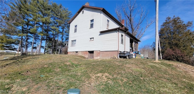 view of property exterior featuring a chimney and a lawn