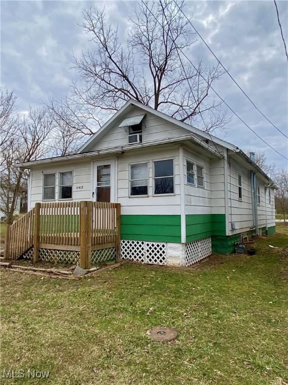 view of front of house with crawl space, a front yard, and a wooden deck