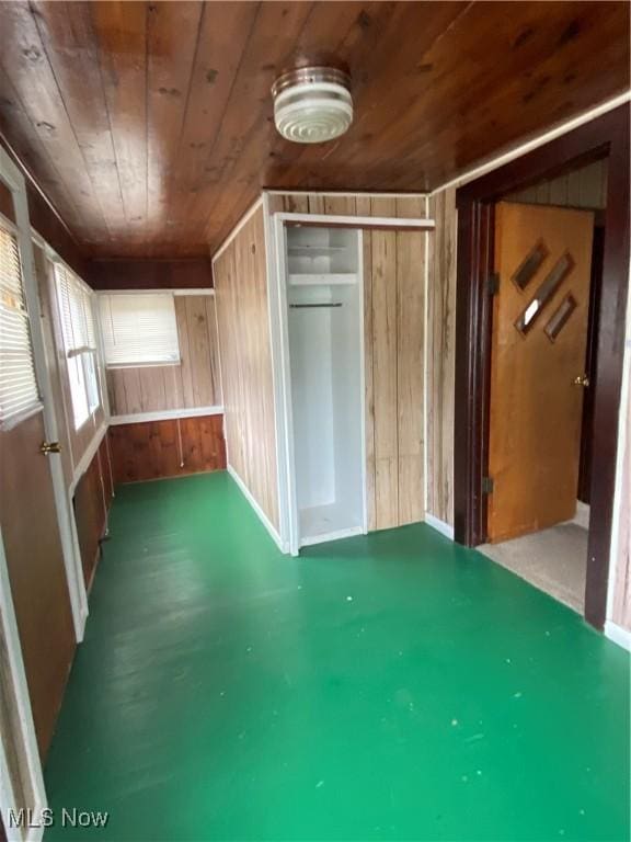 additional living space featuring wooden ceiling and wooden walls