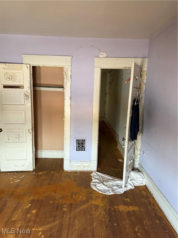 unfurnished bedroom with visible vents and wood finished floors