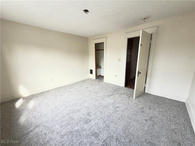 unfurnished bedroom with carpet floors, a closet, and a textured ceiling