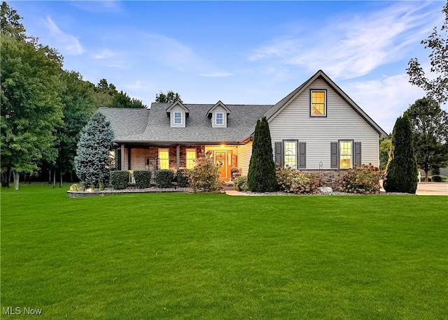 view of front of home featuring a shingled roof and a front yard