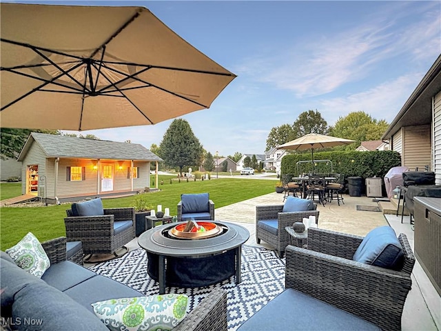 view of patio with an outbuilding, outdoor dining area, and an outdoor living space with a fire pit