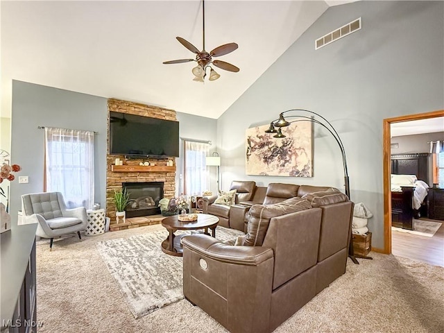 carpeted living area with high vaulted ceiling, a healthy amount of sunlight, visible vents, and a ceiling fan