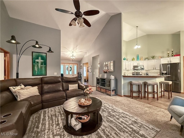 living room featuring light carpet, ceiling fan, and high vaulted ceiling