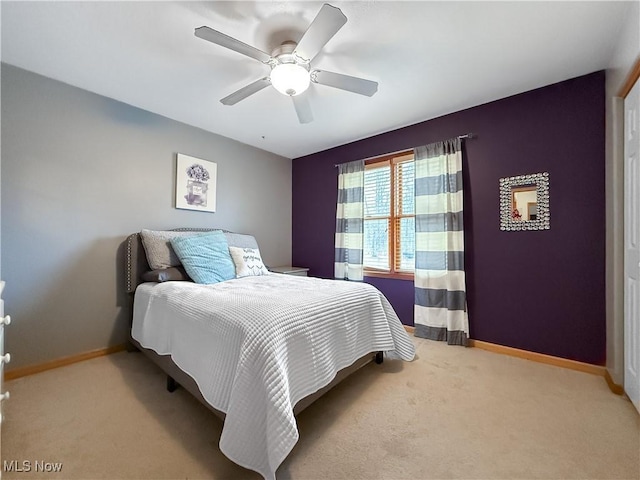 bedroom with light carpet, a ceiling fan, and baseboards