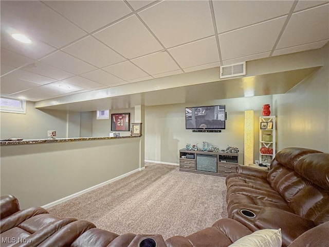 carpeted living area with baseboards, visible vents, and a drop ceiling