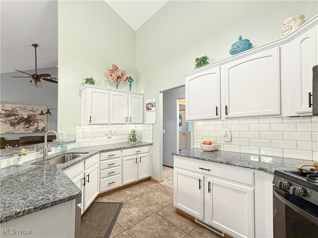 kitchen with stone countertops, a sink, white cabinetry, a ceiling fan, and gas stove