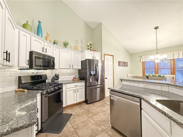 kitchen with white cabinets, appliances with stainless steel finishes, tasteful backsplash, decorative light fixtures, and an inviting chandelier