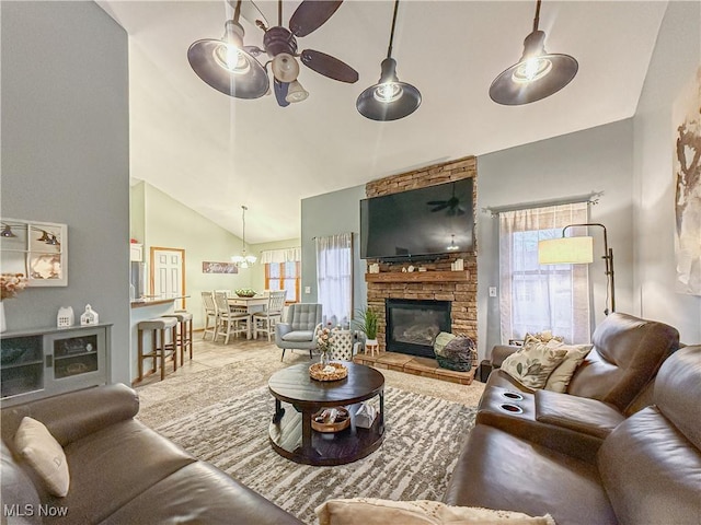 living room featuring high vaulted ceiling, ceiling fan, and a stone fireplace