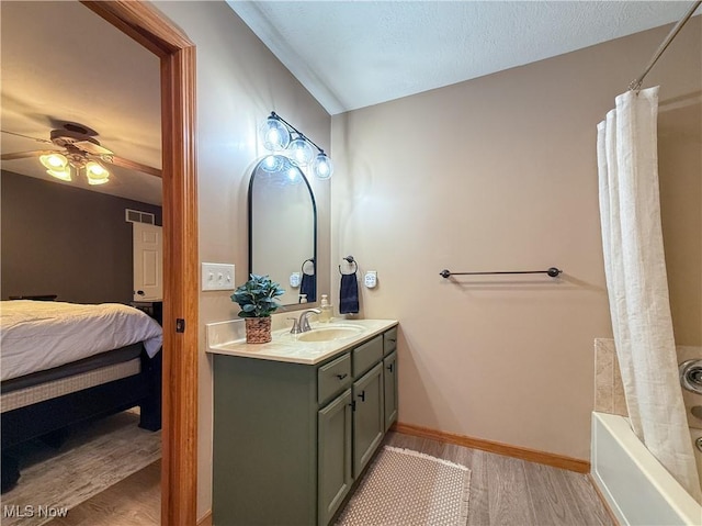 bathroom featuring visible vents, ceiling fan, vanity, wood finished floors, and baseboards