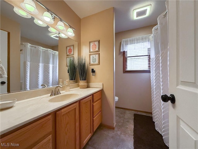 bathroom featuring baseboards, vanity, toilet, and tile patterned floors