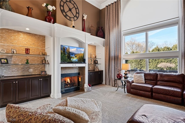 616 Coventry Pl, Amherst, OH 44001 - living room featuring a towering ceiling, a glass covered fireplace, healthy amount of natural light, and light carpet