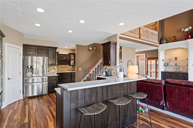 616 Coventry Pl, Amherst, OH 44001 - kitchen with dark brown cabinetry, a peninsula, dark wood-style flooring, light countertops, and stainless steel fridge