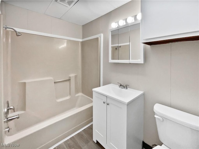 full bathroom featuring visible vents, toilet, tub / shower combination, vanity, and wood finished floors