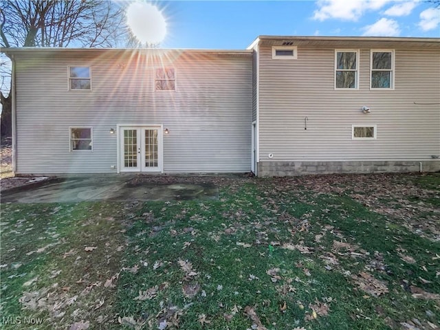 back of property featuring a patio area, a yard, and french doors