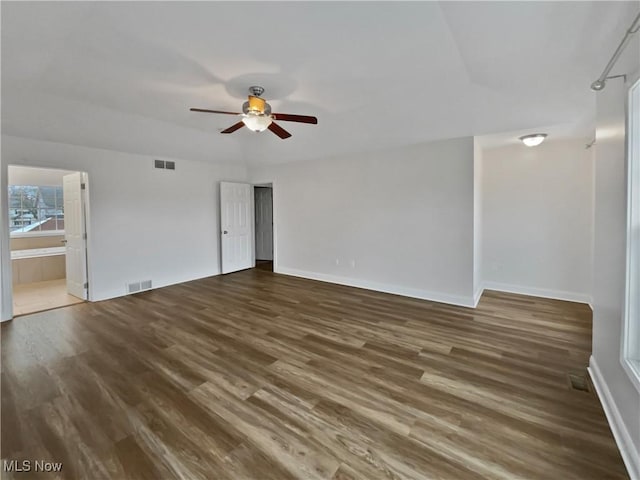 spare room with a ceiling fan, visible vents, and wood finished floors