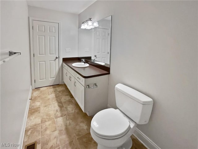 bathroom featuring toilet, visible vents, vanity, and baseboards