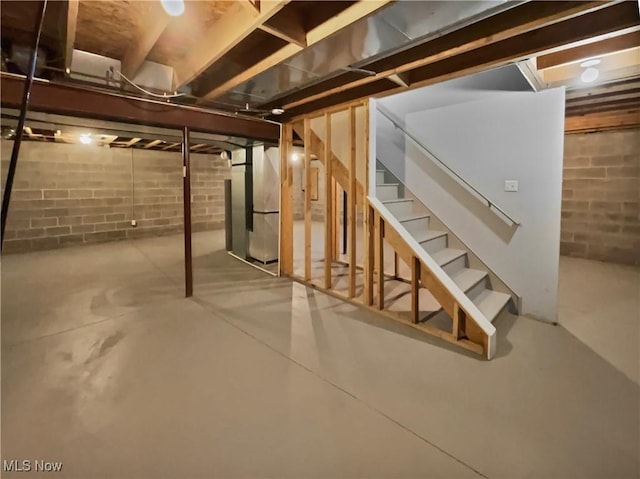 unfinished below grade area with heating unit and stairway