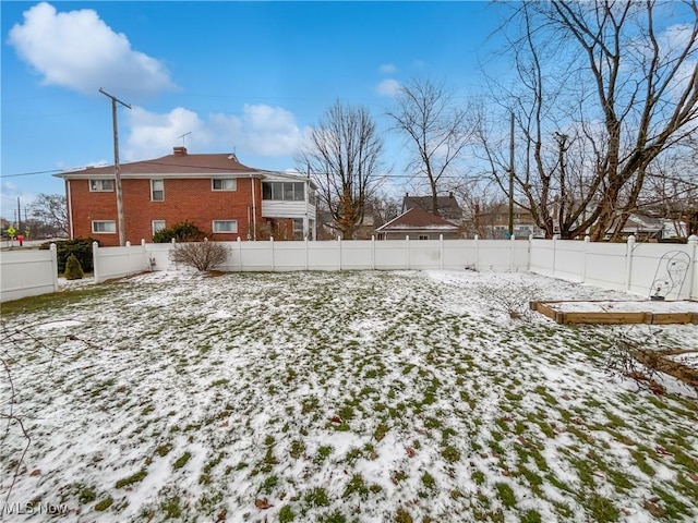 yard covered in snow with a fenced backyard