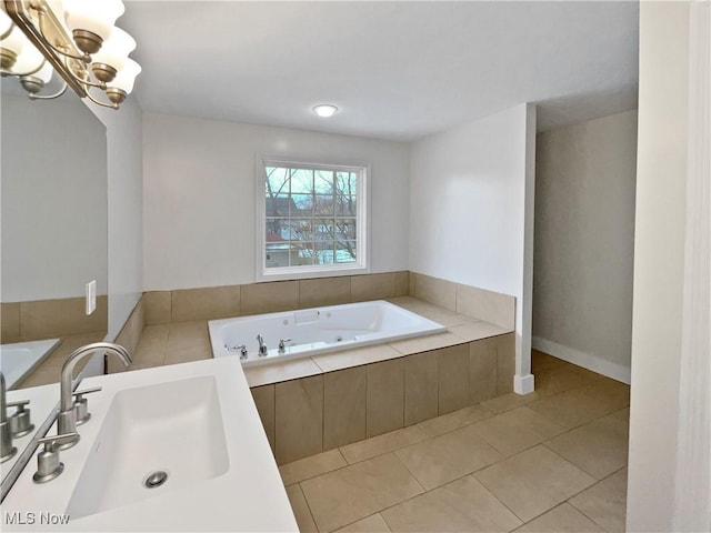 bathroom featuring tile patterned flooring, a sink, a whirlpool tub, and an inviting chandelier