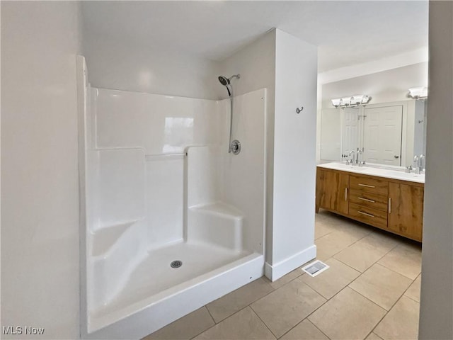 full bathroom featuring double vanity, tile patterned flooring, visible vents, and walk in shower