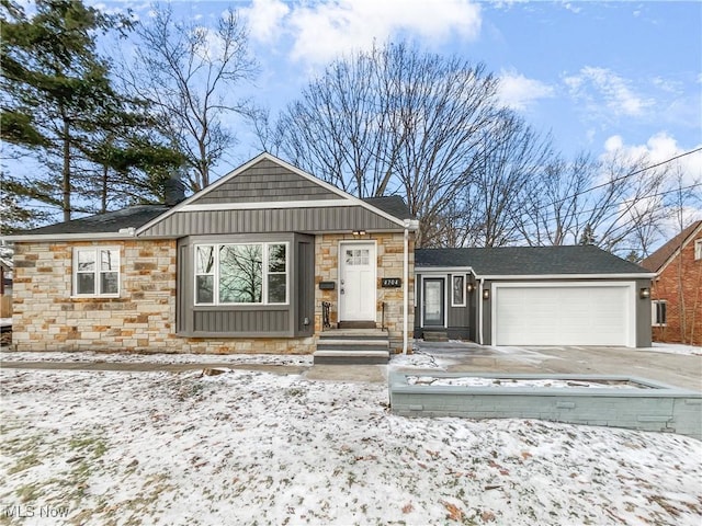 view of front of house featuring a garage, stone siding, board and batten siding, and driveway