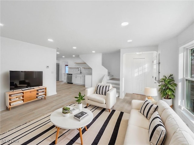 living room with light wood-type flooring, recessed lighting, and stairs