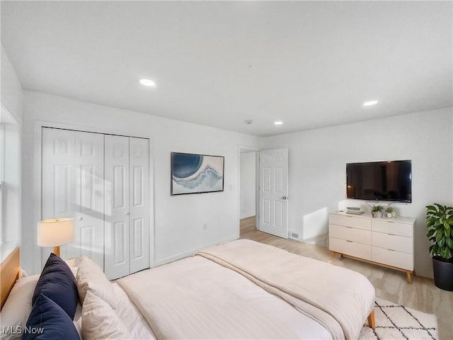 bedroom featuring light wood-style floors, recessed lighting, and a closet