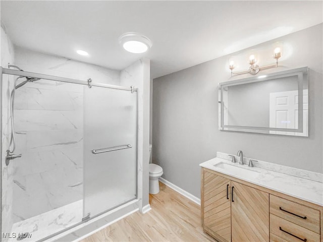 bathroom with toilet, a marble finish shower, and vanity