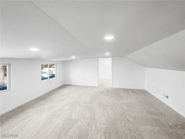 additional living space with carpet floors, recessed lighting, vaulted ceiling, and baseboards