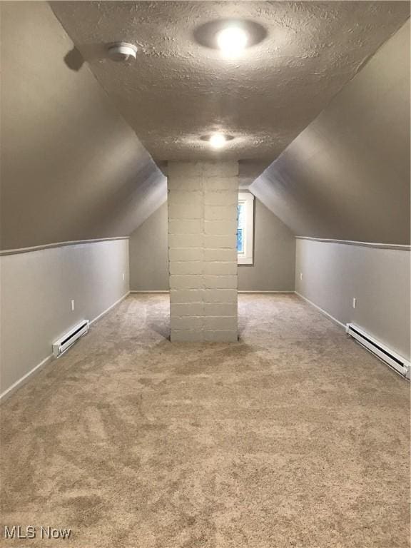 additional living space featuring a textured ceiling, baseboard heating, carpet flooring, and lofted ceiling