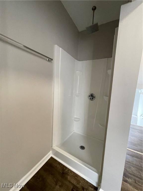 full bath featuring walk in shower, visible vents, baseboards, and wood finished floors