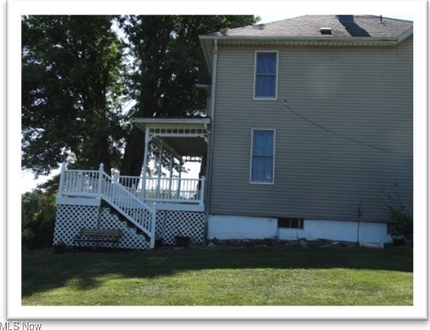 view of side of property featuring a yard and stairway