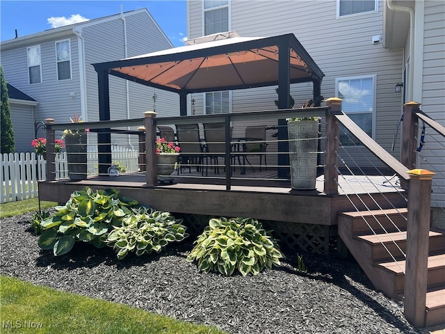 rear view of house featuring a gazebo, fence, and a wooden deck