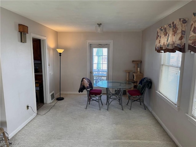 carpeted dining room featuring visible vents and baseboards