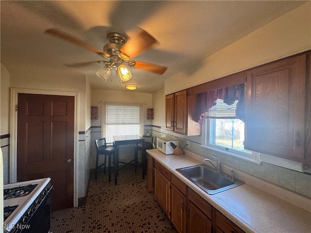 kitchen with light countertops, white appliances, plenty of natural light, and a sink