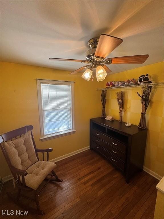 living area featuring dark wood-style flooring, ceiling fan, and baseboards