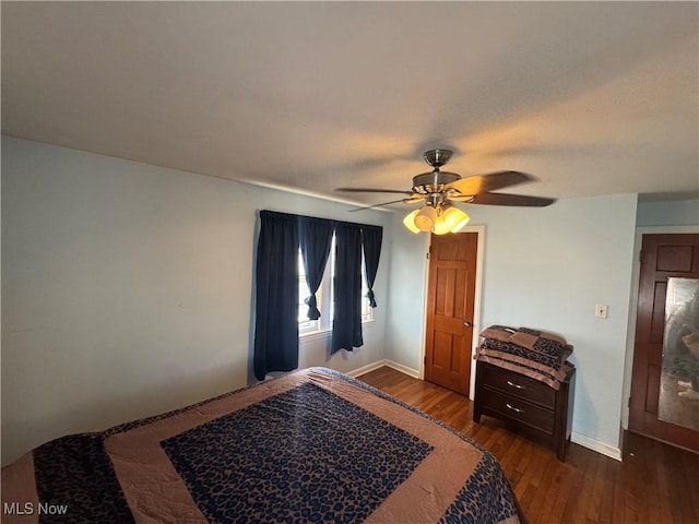 bedroom with a ceiling fan, baseboards, and wood finished floors