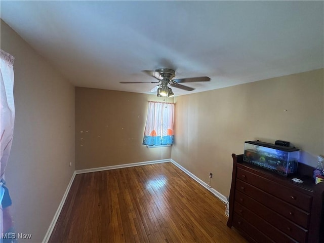 unfurnished bedroom with ceiling fan, baseboards, and hardwood / wood-style floors