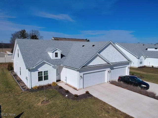 view of front of home with a garage, a front yard, concrete driveway, and a shingled roof