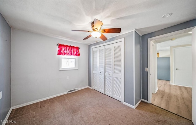 unfurnished bedroom featuring baseboards, carpet, visible vents, and a closet