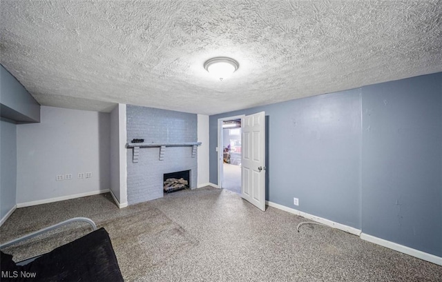 unfurnished living room featuring a brick fireplace, a textured ceiling, and baseboards